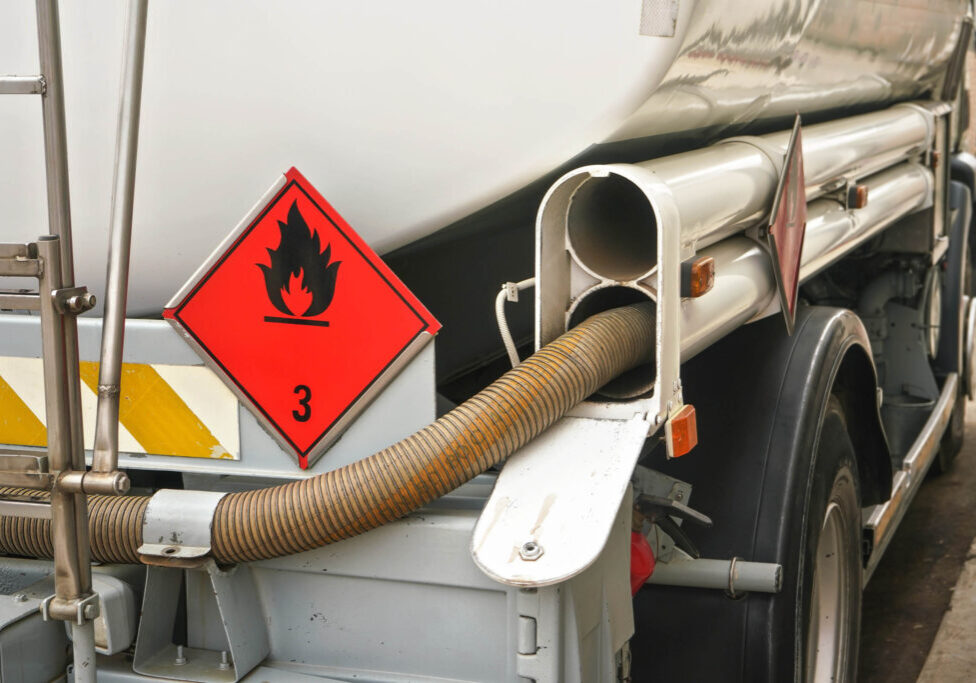 Red Warning hazmat Flammable class 3 liquid sign on back of fuel truck at petrol station