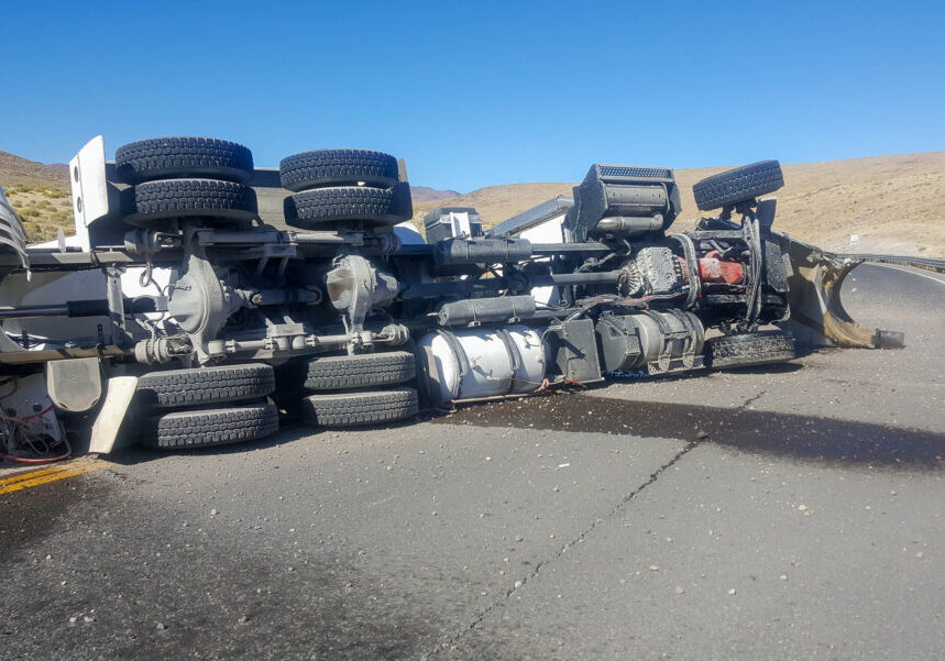 Crashed cement or concrete truck on its side on a roadway.