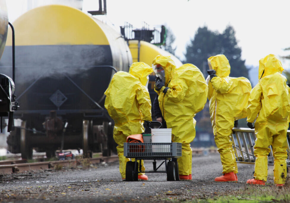 In any urban area the fire departments and emergency response teams will conduct disaster preparedness drills. These HAZMAT team members are suited up with a protective suit to protect them from hazardous materials as they investigate this mock railroad disaster.